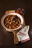 Bowl of Hungarian Beef Goulash Made with Paprika on a Cutting Board; Bowl of Paprika