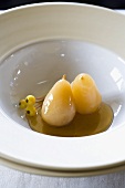 Two Baked Pears with Maple Syrup in a White Bowl