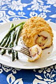 Chicken Cordon Bleu; Sliced on Plate with Fork and Asparagus