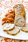 Pork Roast Stuffed and Rolled with Garlic and Herbs; Sliced on Platter with Carrots