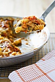 Scooping Johnny Marzetti from Skillet; Rotini Pasta Cooked in a Skillet with Tomatoes and Cheese