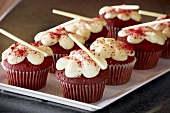 Red Velvet Cupcakes mit Frischkäseglasur und weissen Schokoröllchen