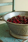 Colander of Fresh Bing Cherries on an Old Wooden Chair