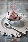 Blueberry Frozen Yogurt in a Small Blue Bowl; On Doily Plate with Spoon