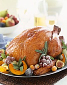 Whole Roasted Turkey on a Platter with Grapes, Figs and Sage