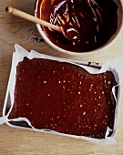 Brownie Batter in a Baking Pan and Mixing Bowl
