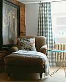 A chaise longue next to a wooden wall with a painting