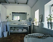Traditionelles Badezimmer in einem Landhaus mit Terrakottafliesen, einem Holzwaschtisch mit zwei Waschbecken und holzvertäfelten Wänden