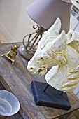 A carved white horse's head on a wooden table
