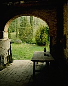 Blick durch einen alten Torbogen auf idyllischen Garten