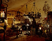 A collection of old chandeliers and candle holders in a cellar