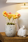 A decorated Easter nest with yellow fabric flowers and a ceramic rabbit