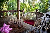 A chess board set out on the terrace in tropical surroundings