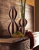 Still life - black and white striped vases on concrete furniture with a back wall