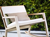 Swing frame chair out of wood with pillow