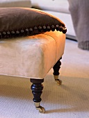 Antique ottoman with castors and a pillow