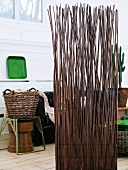 Screen made of willow branches and willow basket on a stool