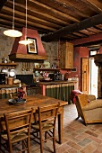 An open-plan living room with a dining area and a kitchen in a rustic Mediterranean county-house