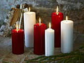 Pine bough in front of burning red and white candles