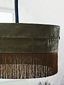 Detail of a black hanging lamp with fringe