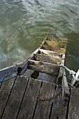 Wooden ladder in water, tied to a jetty