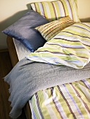 Bed with strip bed linen and decorative pillows