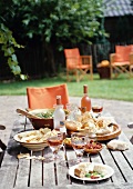 A table laid with antipasti and salad in a garden