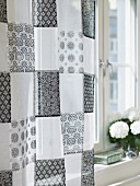 Curtains made of a black and white patchwork-patterned fabric