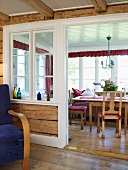 A rustic conservatory with a view of a table and wooden chairs