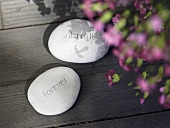 Decorative pebbles with text on a wooden surface