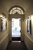 Hausflur mit offenstehender Eingangstür und halbrundem Oberlicht mit Blick auf die Strasse