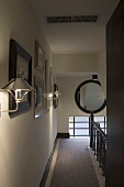 Wandbeleuchtung im Treppenhausflur mit Teppichläufer und Spiegel