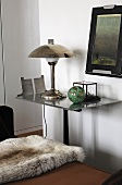 Animal hide on a lounger and a table lamp on a side table with a stainless steel top