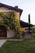 The plant covered stone facade of a Mediterranean villa with a covered terrace