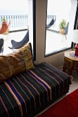 Upholstered seating in front of a window with a view onto the terrace