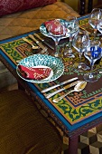 Tischgedeck mit Weingläsern auf orientalisch gemustertem Tisch