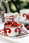 Patterned tea cup with red berries and cherries