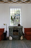 Built-in fireplace under a mullioned window with clam-shaped floor lighting