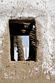 Blick durch Öffnung einer Lehmmauer auf den Palmenstamm, Ägypten