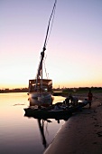 Abendstimmung über Fluss mit Boot und Takelage am Ufer, Nil, Ägypten