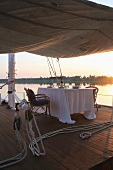 A romantic evening on the river -- table set for tow on the covered sun deck of a boat