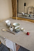 Dishes on a stone countertop in front of a mirror