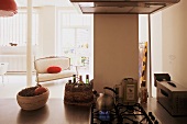 Offene Küche - Küchenblock mit integriertem Gasherd und Blick auf antike gepolsterte Sitzbank im Wohnraum