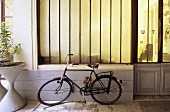 Bicycle parked in a passageway in front of an opaque window