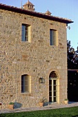 Multi-story country home with natural stone facade in a Mediterranean landscape