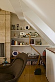 Sloping ceiling with built-in shelves and a floor lamp