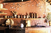 A rustic, African-style kitchen with a painted wall