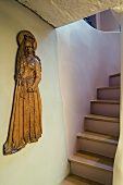 Madonnafigur aus Holz an Wand vor Treppenaufgang