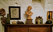Wooden busts and antiques on a wooden cupboard in front of a rustic wall