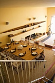 Looking down a flight of stairs at a set table in the open living room of a country home